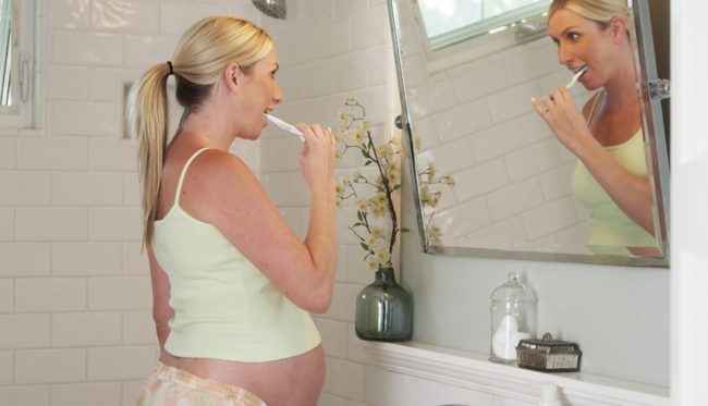 Беременная женщина соблюдающая гигиену области рта