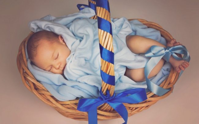 Мальчик новорожденный в синем одеяле в корзинке