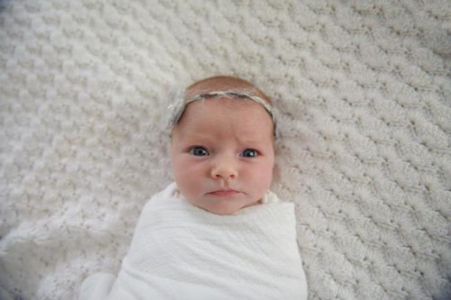 Новорождённая девочка в белой простыне