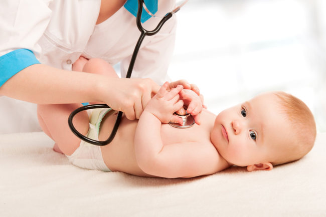 Малыш у врача педиатра прослушиваемый стетоскопом