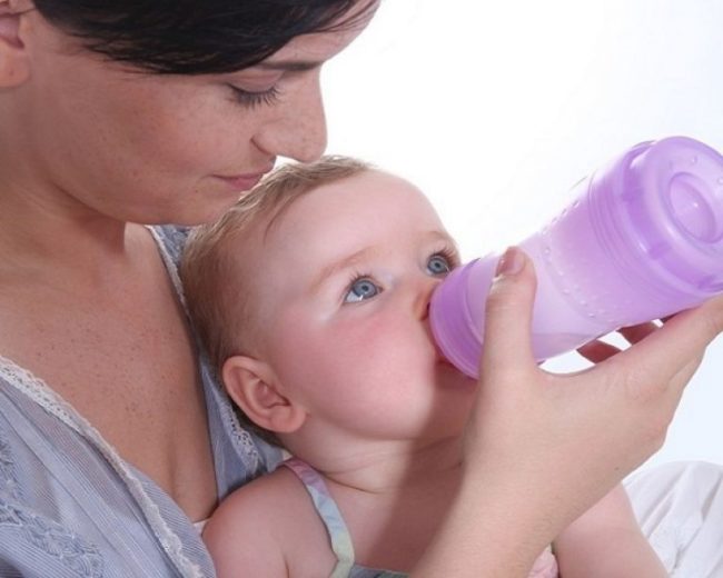 Ребёнок употребляющий укропную воду из бутылочки