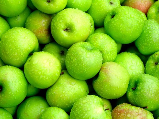 Много зелёных мытых яблок