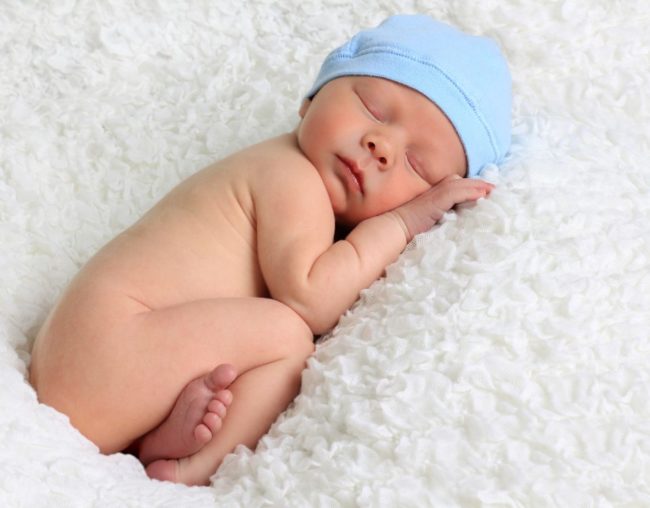 Новорождённый мальчик в шапочке