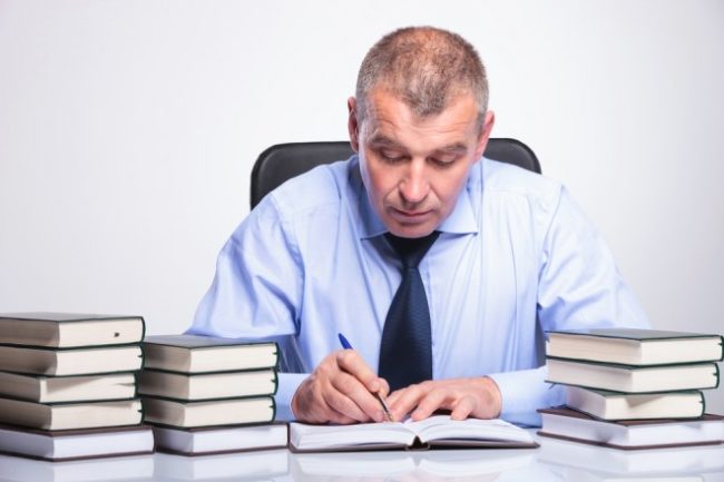 Мужчина в галстуке за столом с книгами