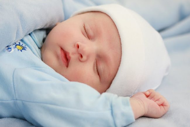 Новорождённый спящий в шапочке