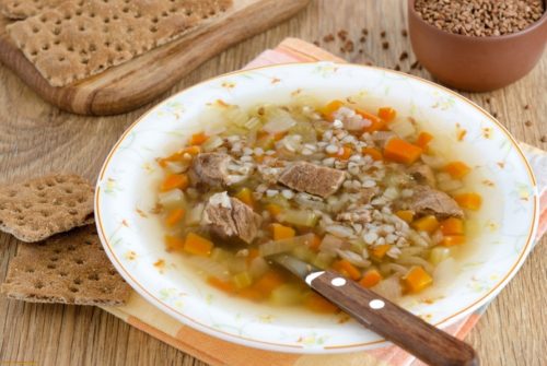 Суп из мяса с гречкой и хлебцами в белой тарелке