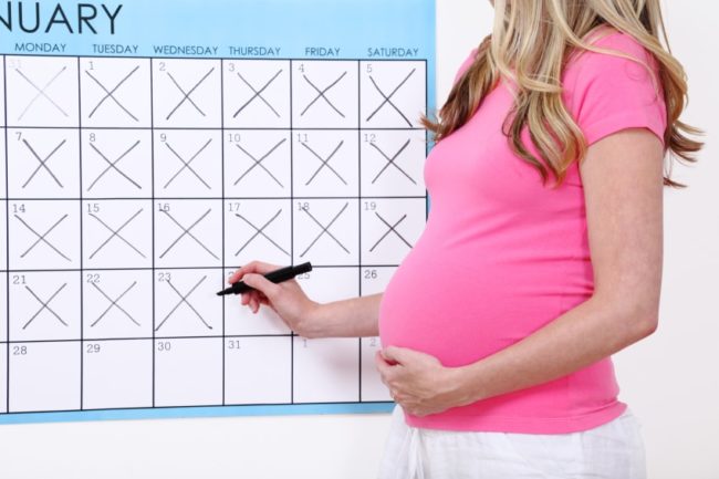 Беременная девушка заполняет календарь