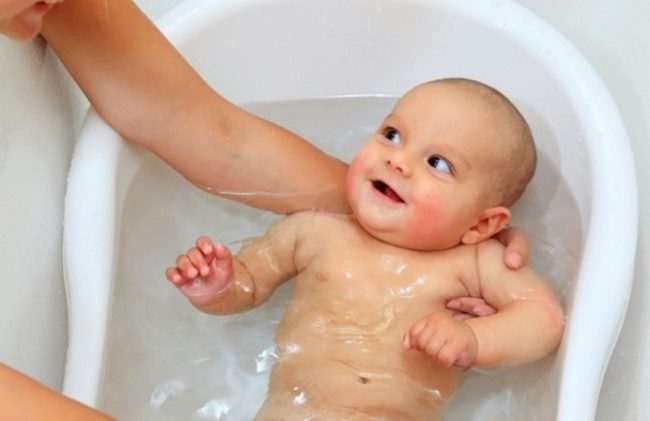 Белая ванночка с водой и новорождённый