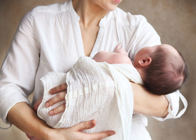Новорождённый малыш на руках матери