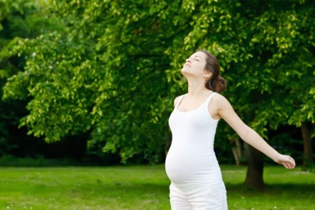Беременная женщина гуляющая на природе