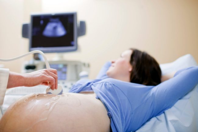 Беременная девушка лежит на УЗИ