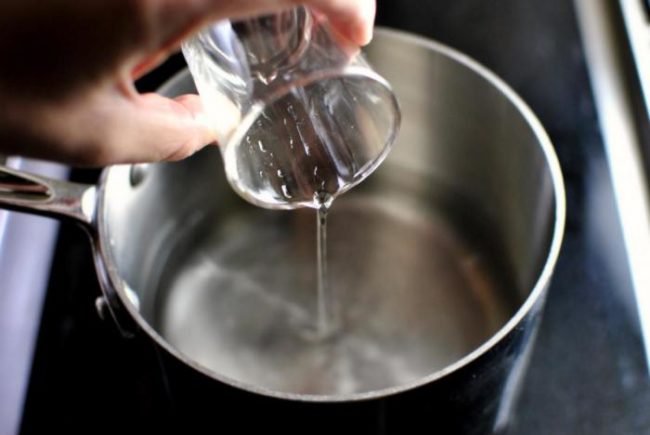 Чистая вода выливаемая из стакана в кастрюлю
