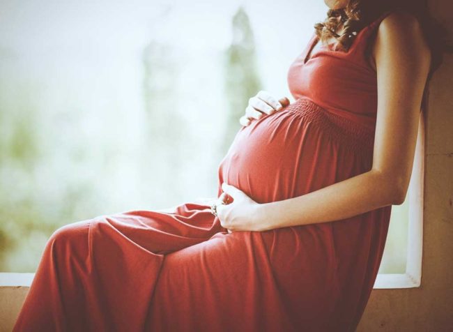 Беременная женщина в красном платье