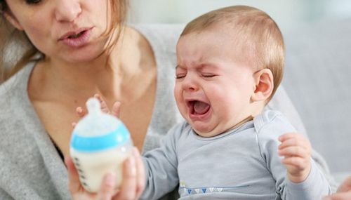 Мама предлагает малышу бутылочку с смесью а ребёнок отказывается и плачет