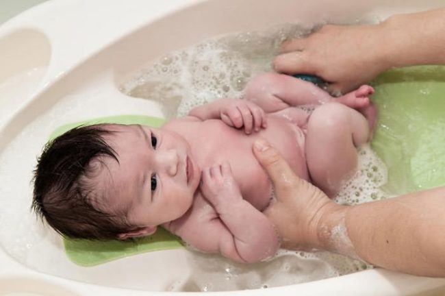 Новорождённый в ванночке с водой