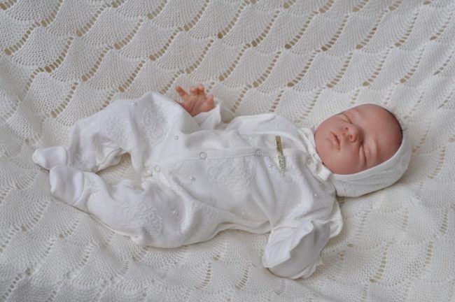 Новорождённый в белой одежде