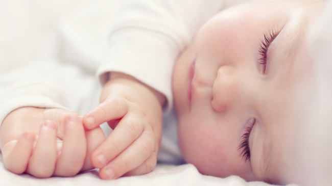 Новорождённый спящий в белой кофточке