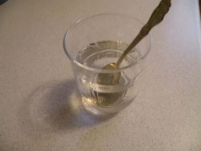 Чистая вода в стакане и ложка