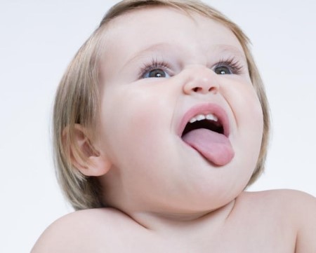 Новорождённая девочка открыла рот и высунула язык