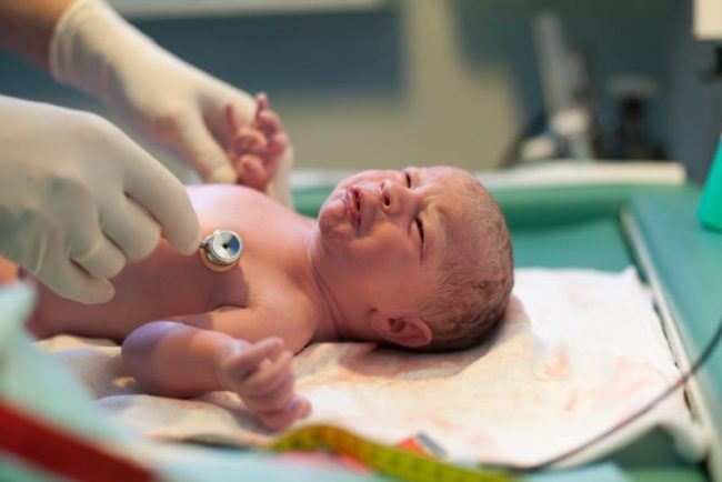 Новорождённый на столе у врача