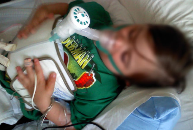 Ребёнок с кислородной маской при осложнении пневмонии