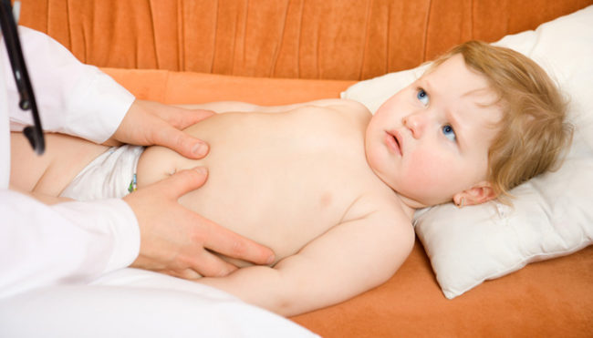 Врач диагностирует вздутие живота у ребёнка