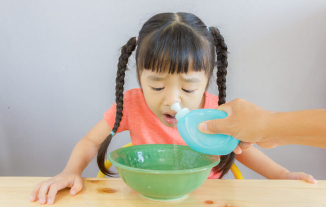 Промывание пазух носа у девочки грушей с солевым раствором