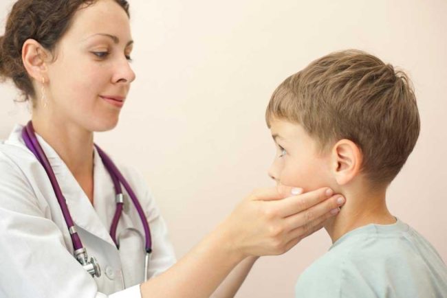 Осмотр ребёнка врачом с воспалённым лимфоузлом