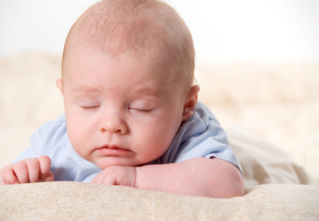 Новорождённый ребёнок спит в необычной позе